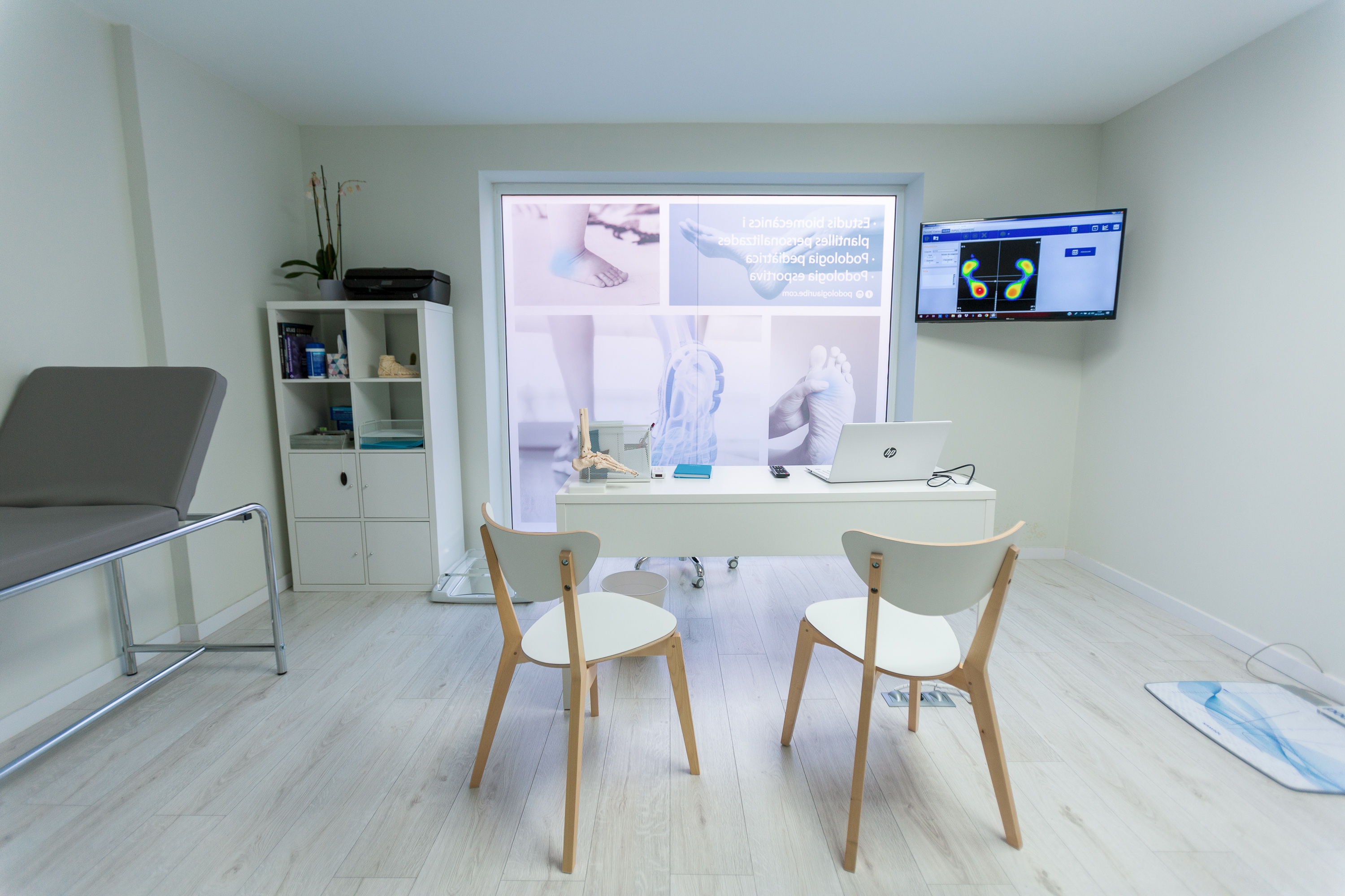 Sala de biomecànica amb taula de treball, pantalles d'anàlisi i llitera